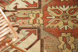 Geometric patterns in rust, ivory, and charcoal on a hand-knotted vintage Kazak rug.