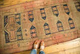 Antique Caucasian runner with horizontally elongated cartouches, geometric motifs in sand, blush, navy.