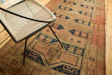 Hand-knotted pile texture with blush, navy, and sand geometric cartouches on an antique Caucasian runner.