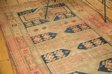 Geometric brown and blush border detail with navy crab designs on an antique Caucasian runner.