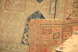 Exposed foundation and small hole visible on sand and blush Caucasian rug.