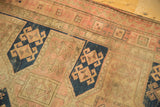 Antique Caucasian runner detail: navy blue cartouche with geometric crab motifs on a sand and blush field.