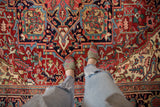 Close-up of classic Heriz carpet's geometric design in ruby red and sapphire blue.
