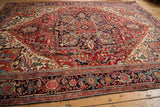 Vintage Heriz rug corner detail with arabesques, ruby red, navy blue, and softened pile.