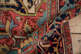 Rolled detail of Vintage Heriz carpet pile, revealing ruby red and navy blue arabesques.
