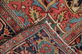 Vintage Heriz carpet's folded corner, showing gem-tone pile, hand knotted reverse, and fringe.