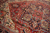 Intricate arabesque motifs in ruby red, sapphire blue, and cream on a vintage Heriz rug.