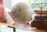 Detailed lunar surface of the 1970s moon globe on its clear acrylic base.