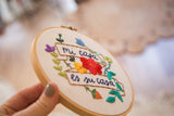 Mi Casa Es Su Casa embroidery hoop art, intricate floral details and hand-stitched text.