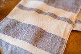 Textured handwoven cotton dish towel featuring navy blue and cream ticking stripes.