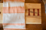 Handwoven Loomination dish towel featuring tangerine orange and cream feedsack stripes.