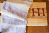 Handwoven lavender and white striped dish towel, folded, measuring 18 x 26 inches.