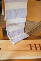 Handwoven lavender and off-white striped cotton dish towel texture close-up.