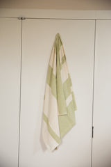 The soft drape of a hand-woven cotton throw with lime green stripes.