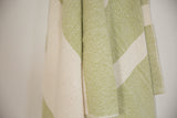 Absorbent textured weave of a handwoven cotton throw in lime green and cream.