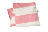 Hand-woven cotton spa towel with wide ticking stripes in scarlet red and cream, shown folded.