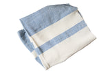 Folded hand-woven cotton spa towel with blue and cream ticking stripes.