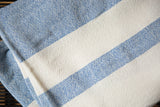 Hand-woven cotton spa towel detail with blue and cream ticking stripes and textured weave.