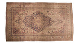 Antique Kermanshah carpet with a scalloped navy medallion and cochineal red florals on an ivory field.