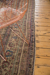 Intricate floral borders and time-softened pile of an antique Kermanshah Persian carpet.
