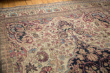 Texture of the antique Kermanshah carpet's low pile with knot heads visible amidst intricate vinery.