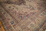 Floral cross-sections and scrolling tendrils on the corner of an antique Kermanshah carpet.