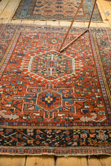 Lower border detail of a vintage Karaja rug with dark teal geometric motifs and fringe.