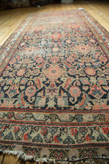 Worn fringed end of antique Hamadan rug, showing meandering leaf border and Herati pattern.