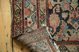 Antique Hamadan rug corner revealing herati pattern, rich abrash, hand-knotted foundation, tattered fringe.