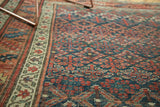 Antique Kurdish Bijar rug's repeating henna plant design in indigo, apricot, and oxidized green.