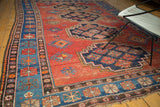 Indigo stepped medallion and gul motifs on the terra cotta field, showing even wear, vintage Caucasian rug.