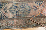 Antique Persian Malayer rug corner, blush field, navy Herati spandrel, and floral borders.