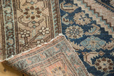 Antique Malayer rug corner folded, showing deep blue Herati motifs and woven reverse in muted tones.
