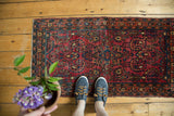 Hand-knotted vintage German Sarouk runner showcasing an even pile texture and vibrant floral motifs.