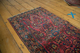 Vintage German Sarouk rug, cranberry red field with blue floral bouquets and pinwheel designs.