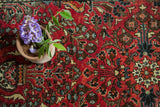 Close-up vintage Persian Sarouk runner with cherry red field and intricate floral vase motifs.