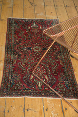 Curvilinear floral motifs in navy, teal, and beige on the cherry red field.