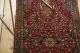 Ornate floral and vine patterns with detailed borders on the cherry red vintage Sarouk runner.