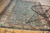 Geometric arabesque border alongside the soft Herati pattern of a vintage Malayer rug.