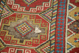 Antique Caucasian rug detail: geometric gul panel, checkered inlay, and exposed foundation.