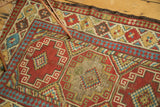 Antique Caucasian rug's primitive geometric guls, checkered diamonds, tatter, and holes.
