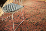 Aged blush and navy blue gul motifs on an antique Afghan Ensi carpet.