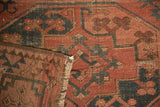Folded antique Afghan Ensi carpet detailing gul motifs, wear, and restored selvage.