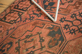 Geometric oversized gul motifs in dark blush and navy charcoal on an antique Ensi carpet.