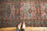Vintage Mehriban rug's oversized geometric pattern in dusty magenta, terra cotta rust, and teal.