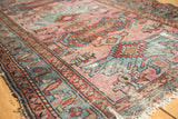 Worn rust and blue border of vintage Mehriban rug, with tattered fringe and oversized motifs.