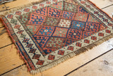 Antique Jaff Kurd rug's geometric diamond lattice of madder red, indigo, and ivory.