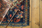 Vintage Borchalou rug corner showing oversize geometric floral motifs in indigo, terra cotta.