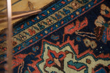 Hand-knotted Borchalou rug detail: indigo, terra cotta, and beige geometric pattern, even wear.