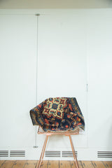 Playful vintage Borchalou rug draped, featuring oversize quatrefoil medallion and floral blossoms on indigo blue.